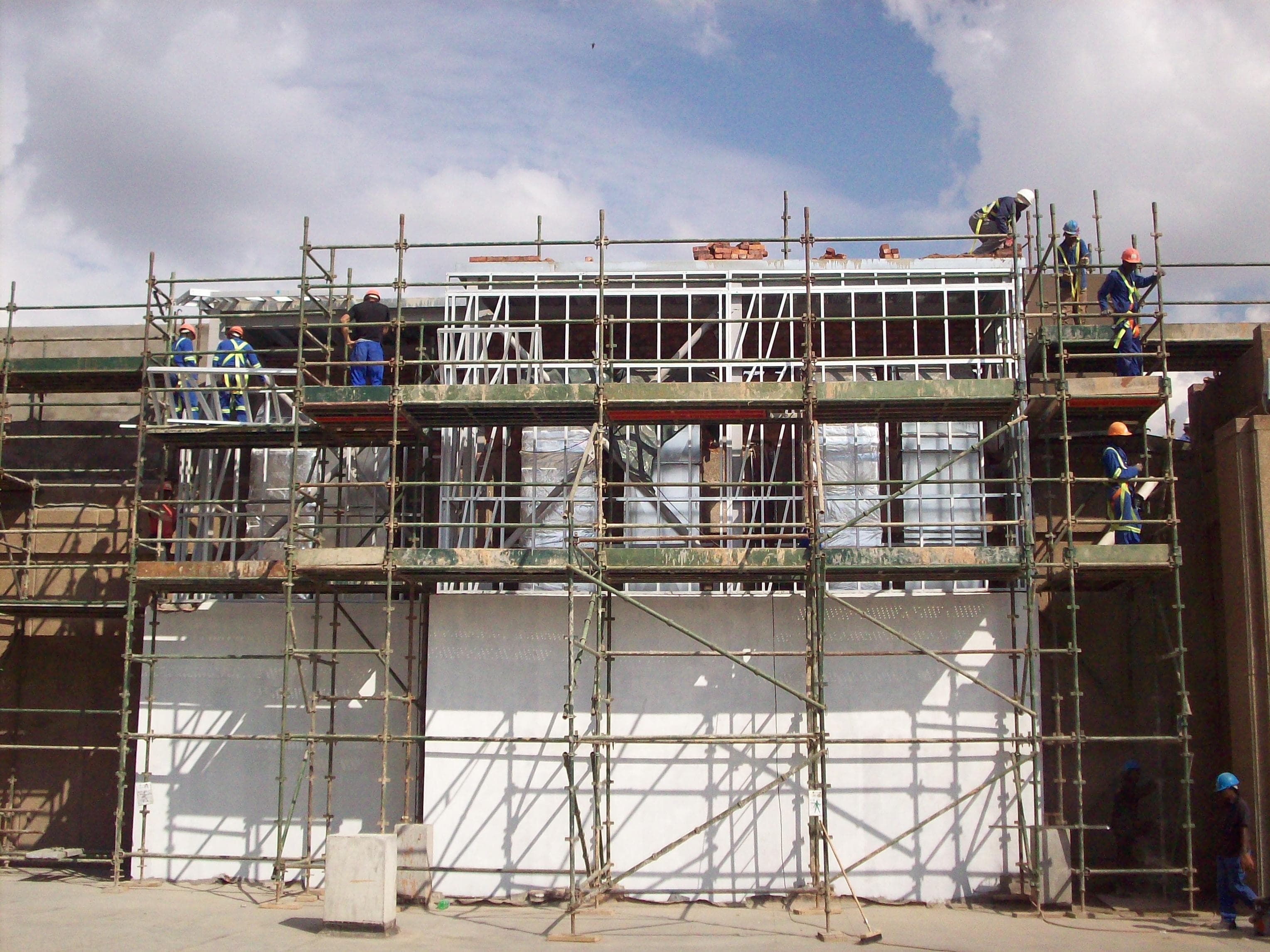 Workers installing lightweight steel framing on a commercial building facade